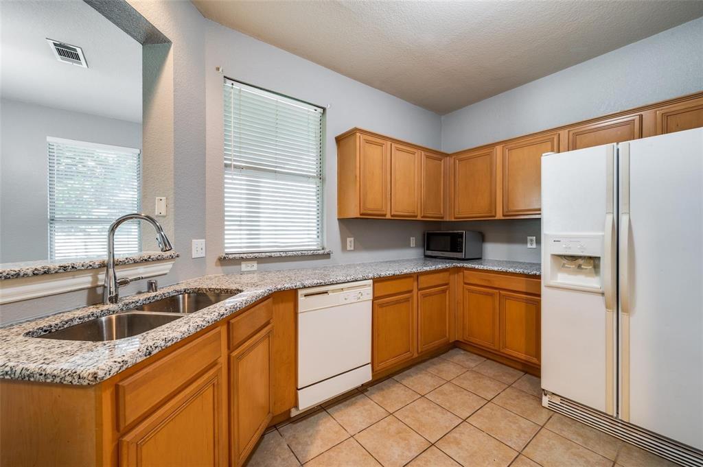9801 Cedarcrest Drive Providence Village, TX 76227 - Photo 17 of 23 a kitchen with stainless steel appliances granite countertop a sink stove and refrigerator