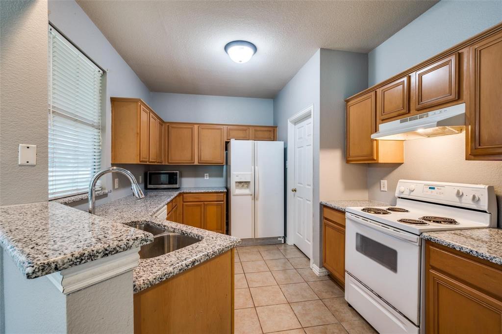 9801 Cedarcrest Drive Providence Village, TX 76227 - Photo 18 of 23 a kitchen with stainless steel appliances granite countertop a sink stove and refrigerator