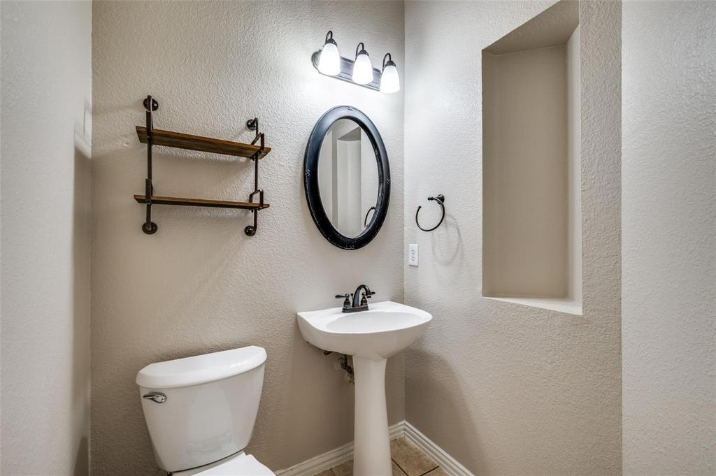 9801 Cedarcrest Drive Providence Village, TX 76227 - Photo 19 of 23 a bathroom with a toilet a sink and a mirror