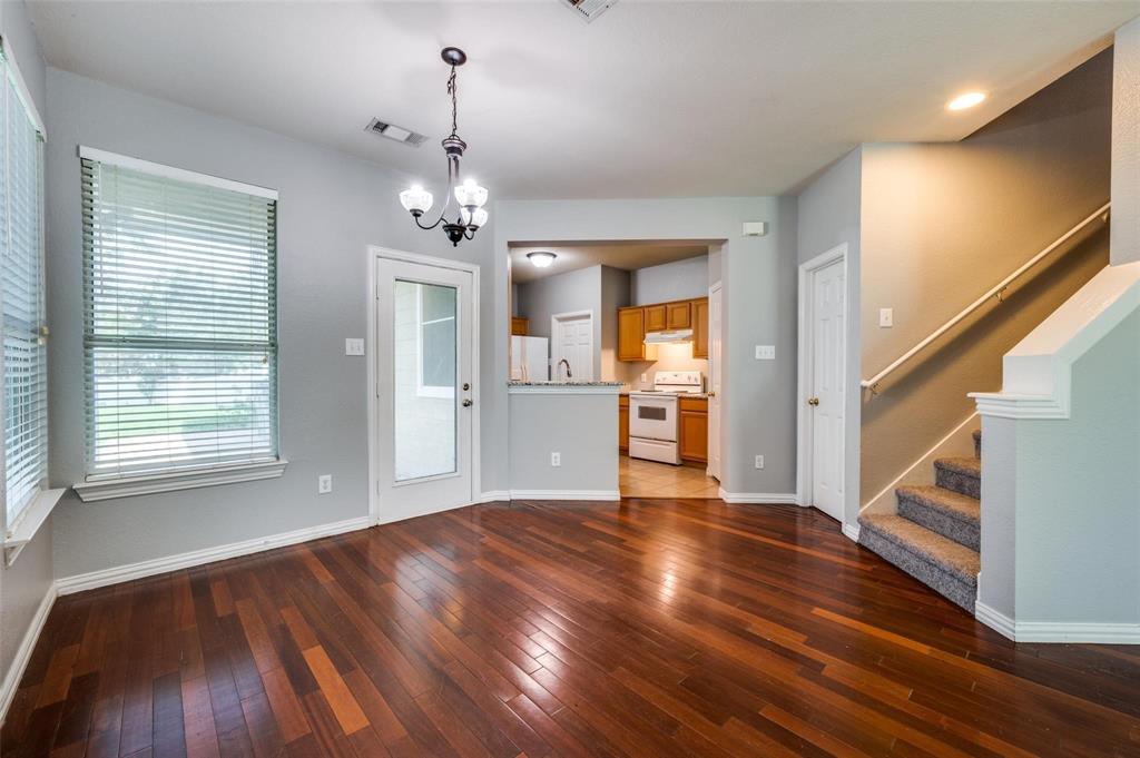9801 Cedarcrest Drive Providence Village, TX 76227 - Photo 20 of 23 a view of a room with wooden floor staircase and a kitchen