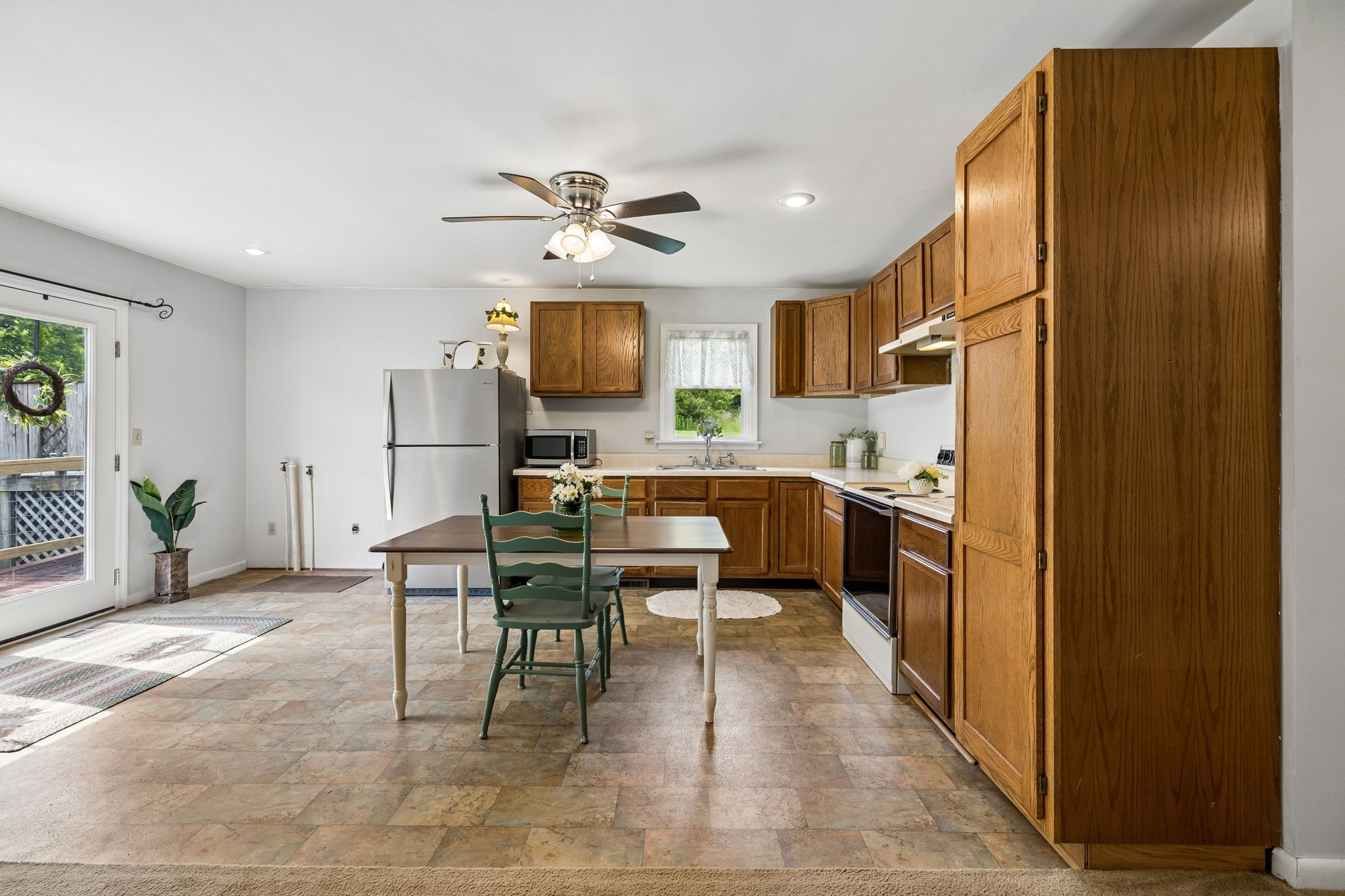 115 1st Street Monteagle, TN 37356 - Photo 8 of 22 a kitchen with stainless steel appliances kitchen island granite countertop a refrigerator a stove a microwave oven a dining table and chairs with wooden floor