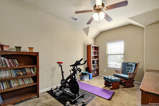 a living room with furniture a bookshelf and a window