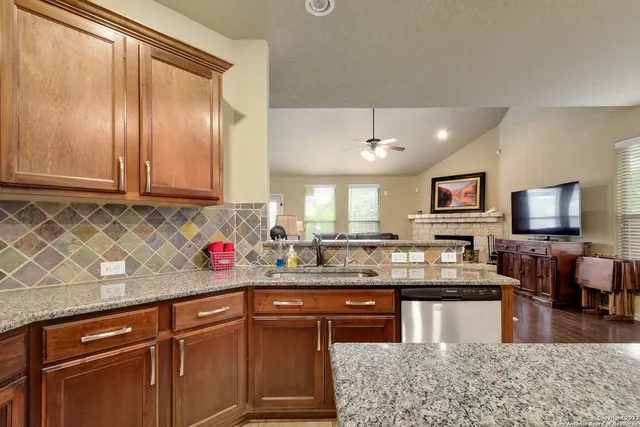 a kitchen with stainless steel appliances granite countertop wooden cabinets a sink and dishwasher