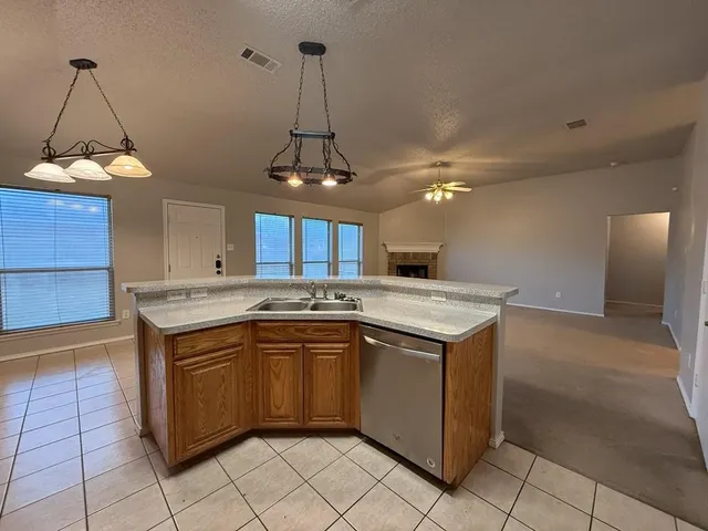 a kitchen with a sink a stove top oven and cabinets