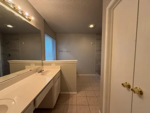 a bathroom with a tub sink and mirror