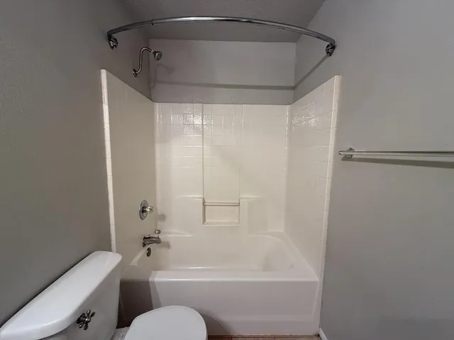 a bathroom with a sink a toilet a mirror and shower