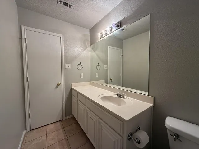 a view of a yard with a large tree in front of it