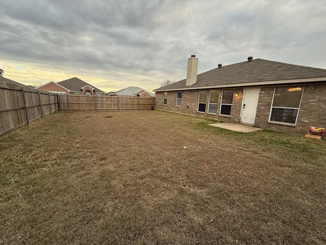 a backyard of a house with wooden fence