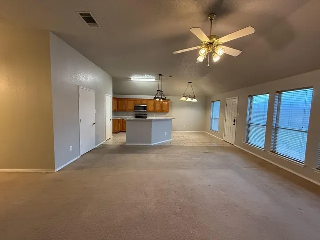 a view of a livingroom with a ceiling fan and window