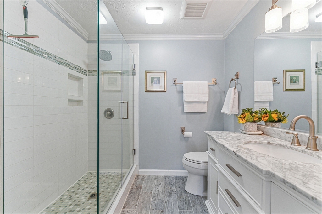 3 Heather Hill Road Acton, MA 01720 - Photo 19 of 33 a bathroom with a granite countertop sink a toilet and shower