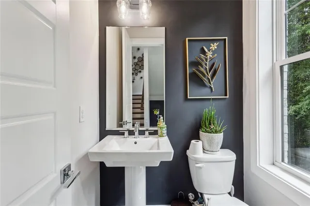 a bathroom with a toilet a sink and a mirror