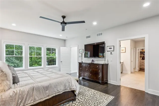 a spacious bedroom with a bed and a television