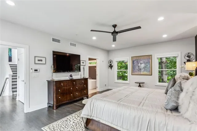 a spacious bedroom with a bed and a flat screen tv