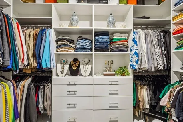 a view of walk in closet with clothes and shoes