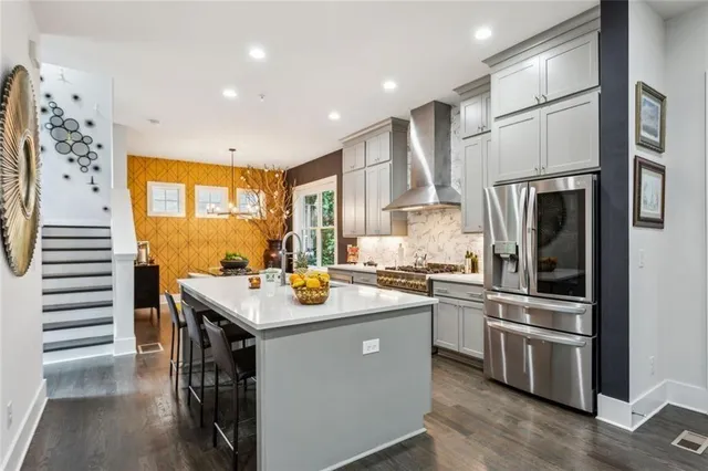 a kitchen with stainless steel appliances granite countertop a sink a stove and a refrigerator