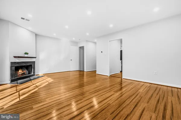 a view of empty room with wooden floor and fireplace