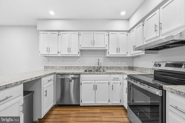a kitchen with granite countertop a sink stainless steel appliances and cabinets