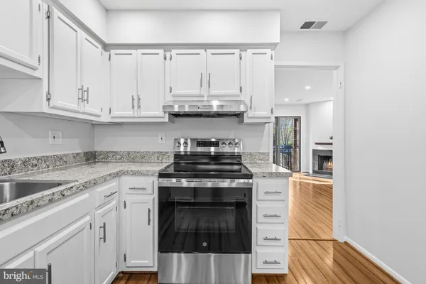 a kitchen with granite countertop white cabinets and white appliances