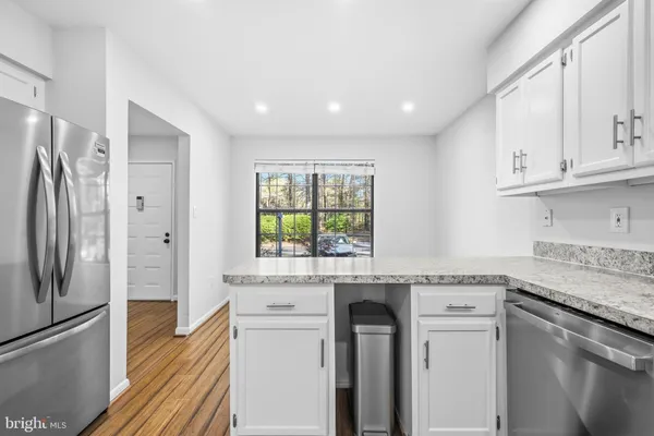 a kitchen with granite countertop white cabinets and white appliances