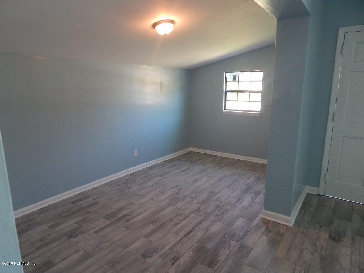 2935 Sandhurst Road East Jacksonville, FL 32277 - Photo 6 of 15 an empty room with wooden floor and windows
