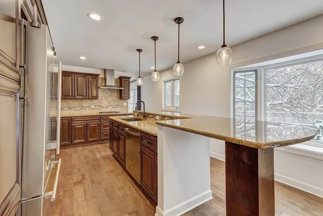 a open kitchen with stainless steel appliances granite countertop a sink a stove and a refrigerator