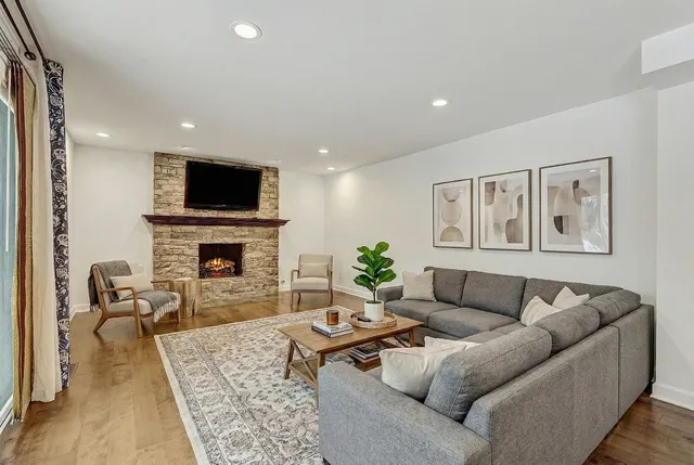 a living room with furniture a fireplace and a flat screen tv