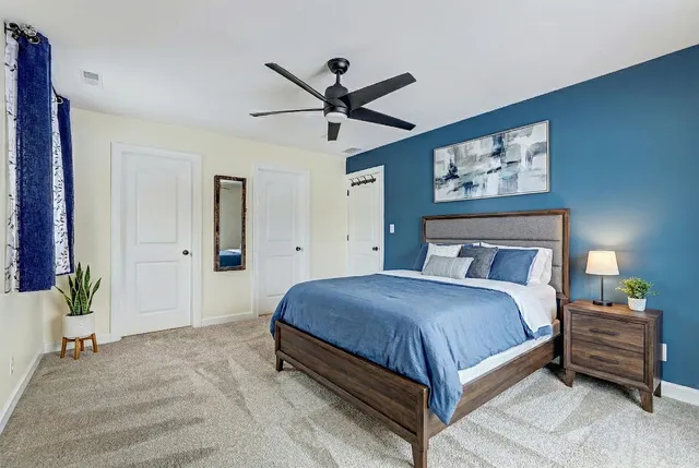 a bedroom with a bed and painting on the wall