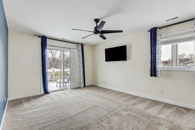a view of an empty room with a window and a flat screen tv