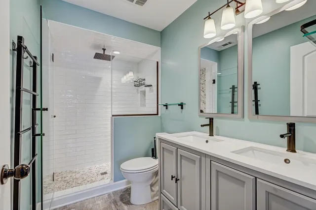 a bathroom with a sink a toilet and shower