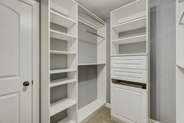 a view of walk in closet with empty racks