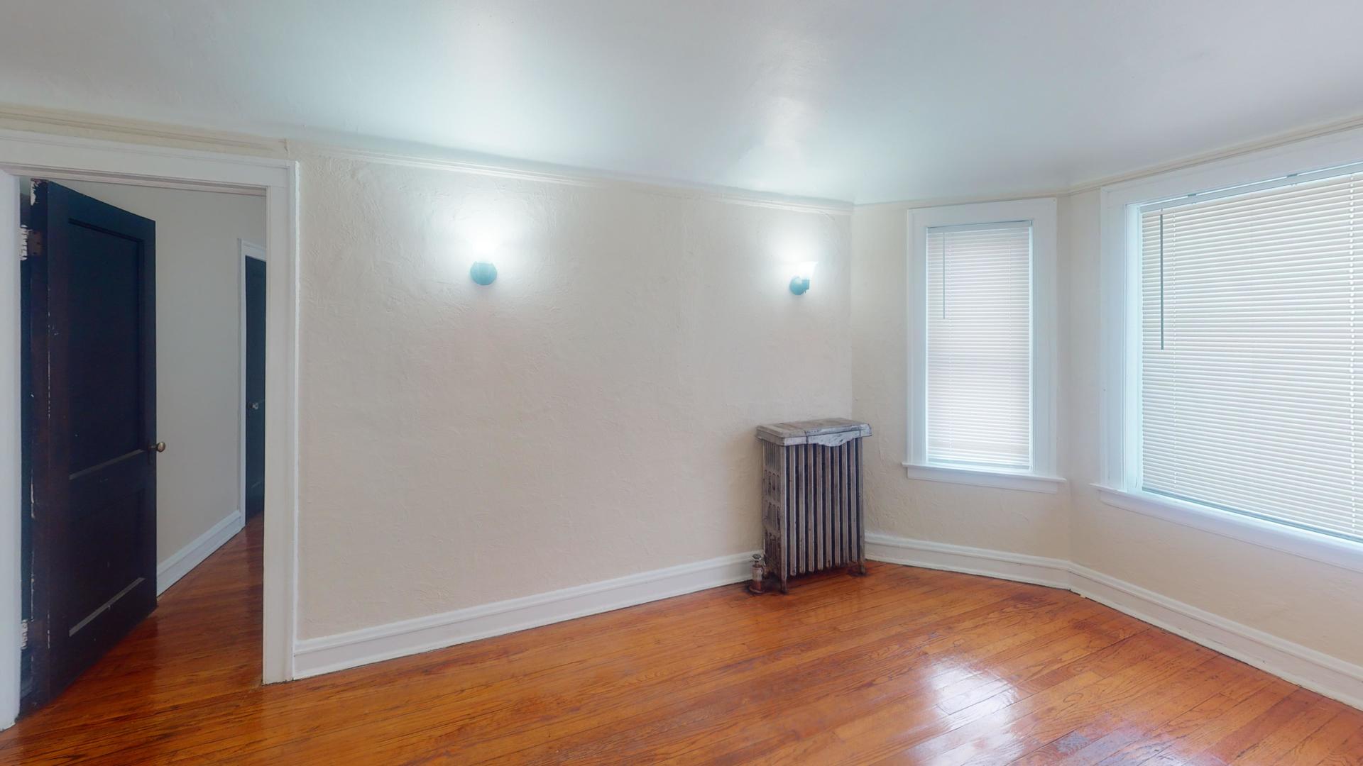 621 East 89th Place, Unit 1N Chicago, IL 60619 - Photo 3 of 8 an empty room with wooden floor and windows