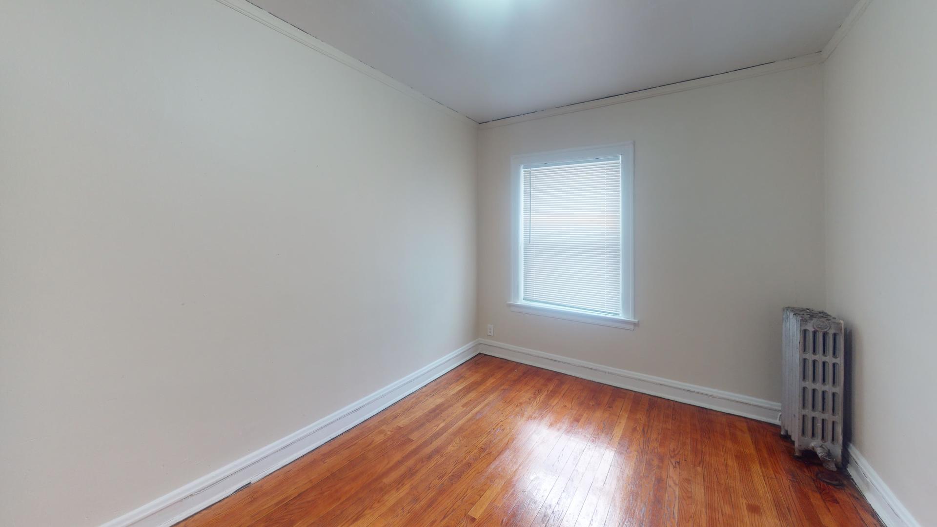 621 East 89th Place, Unit 1N Chicago, IL 60619 - Photo 4 of 8 a view of an empty room with wooden floor and a window