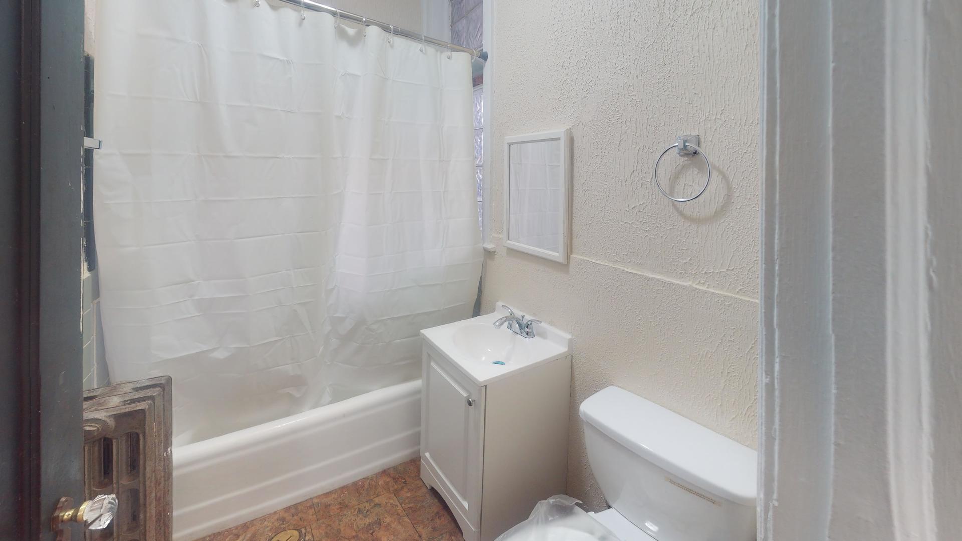 621 East 89th Place, Unit 1N Chicago, IL 60619 - Photo 5 of 8 a bathroom with a sink a toilet and shower