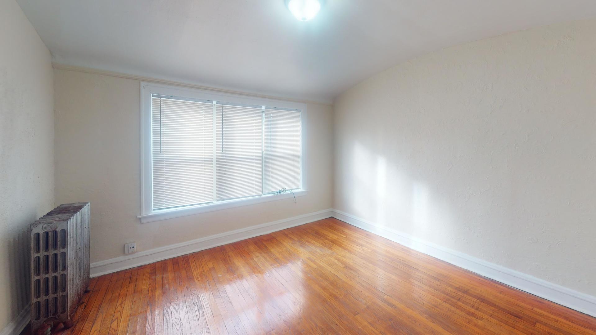621 East 89th Place, Unit 1N Chicago, IL 60619 - Photo 6 of 8 an empty room with wooden floor and windows