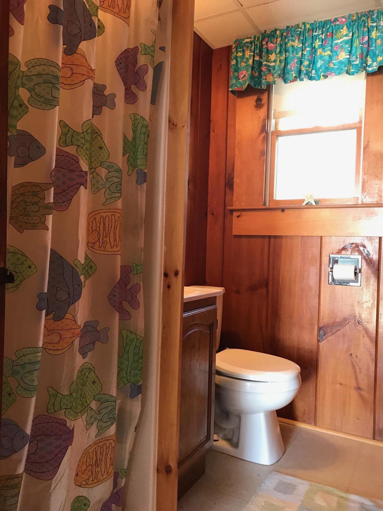 140 Old Wharf Road, Unit 2 Dennis Port, MA 02639 - Photo 13 of 22 a white toilet sitting next to a shower curtain