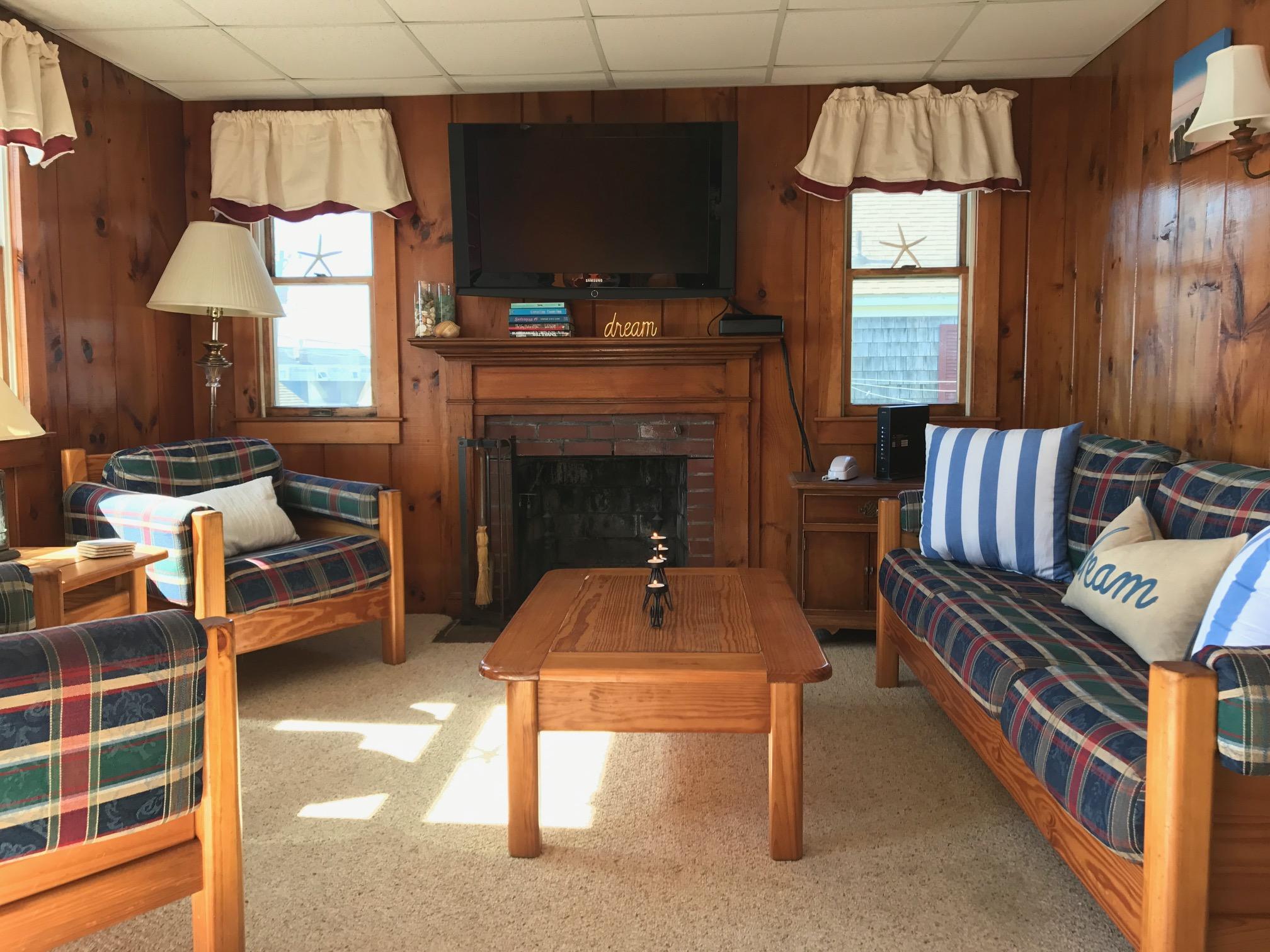 140 Old Wharf Road, Unit 2 Dennis Port, MA 02639 - Photo 3 of 22 a living room with furniture a fireplace and a flat screen tv