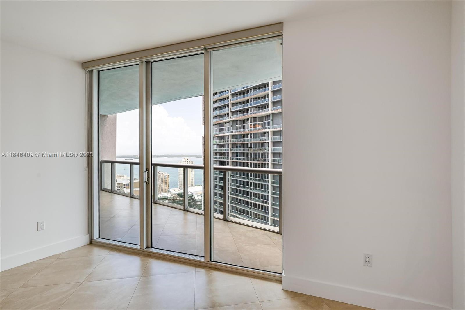 475 Brickell Avenue, Unit 3811 Miami, FL 33131 - Photo 18 of 21 an empty room with wooden floor and windows