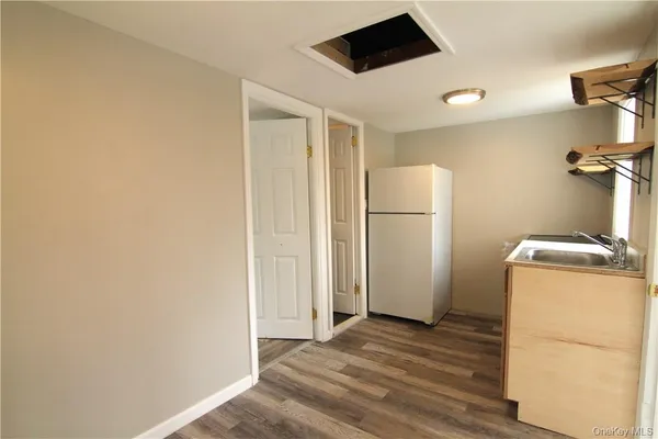 a view of a storage & utility room with a refrigerator