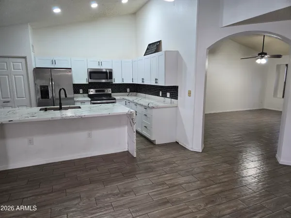 a kitchen with stainless steel appliances a refrigerator sink and white cabinets