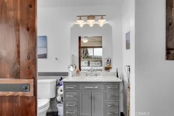 a bathroom with a sink vanity granite toilet and shower