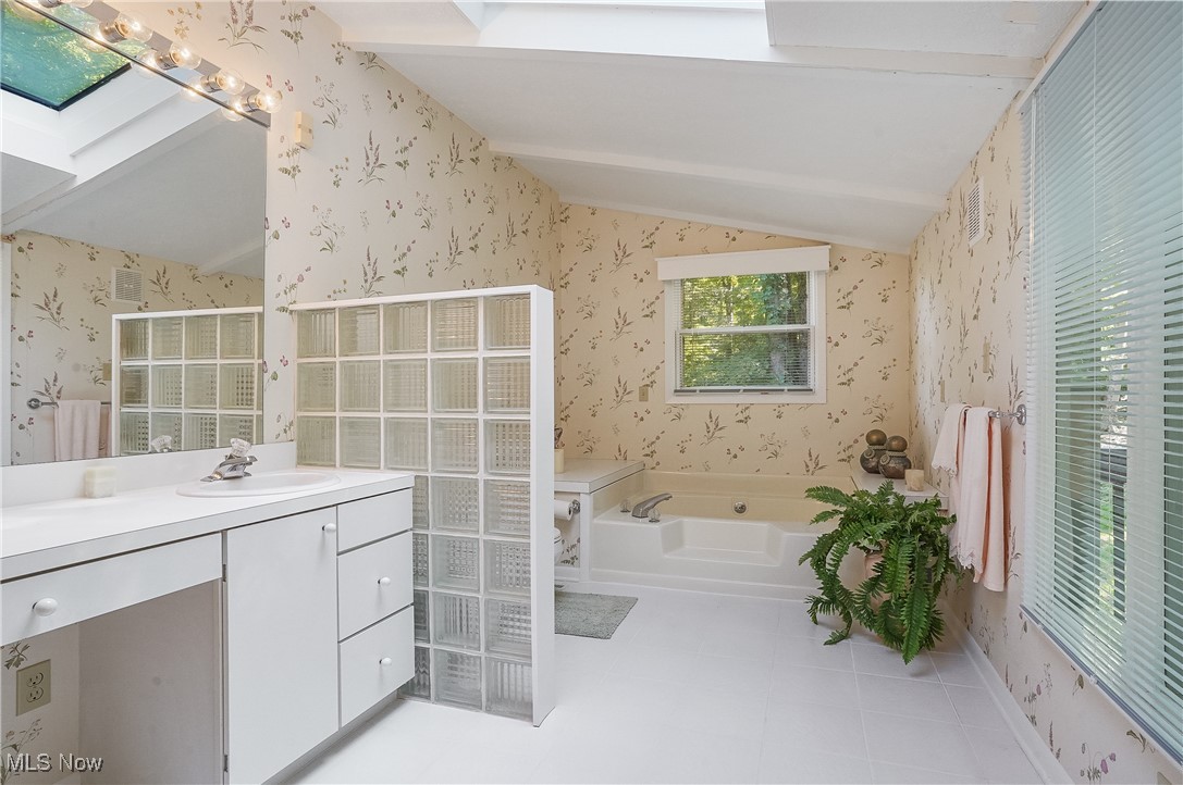 3680 Granger Road Akron, OH 44333 - Photo 22 of 40 Bathroom featuring vanity, independent shower and bath, and lofted ceiling with skylight