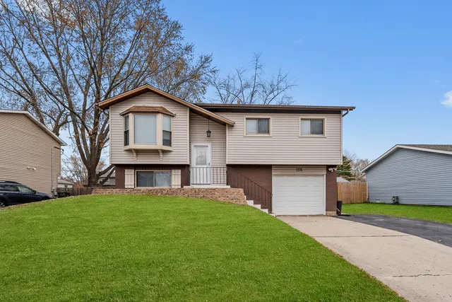 a front view of a house with a garden and yard