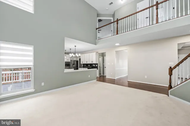 a view of a livingroom with wooden floor and staircase