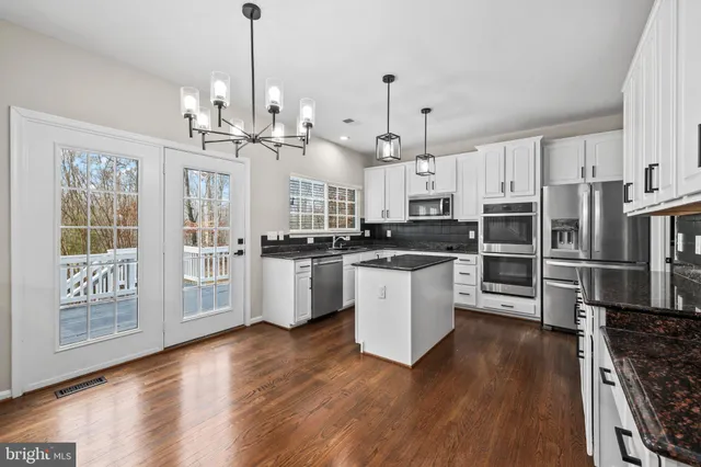 a kitchen with stainless steel appliances granite countertop a sink a stove and dishwasher