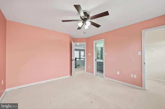 an empty room with closet and a ceiling fan