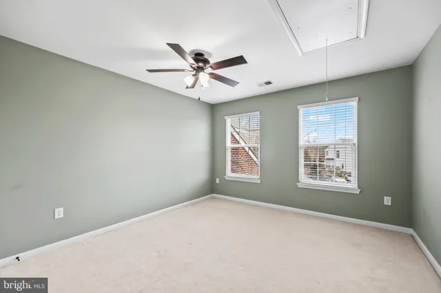 a bedroom with a large bed and a chandelier fan