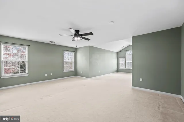 a living room with furniture a clock and a potted plant