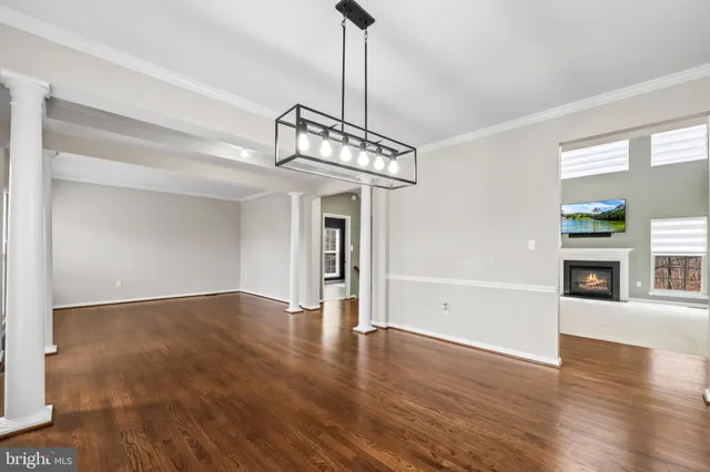 a view of a livingroom with wooden floor a fireplace and windows