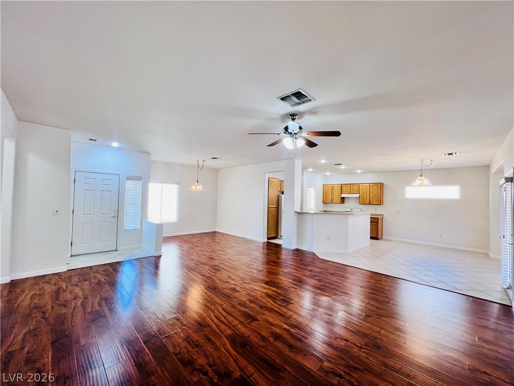 3047 Hickory Valley Road Henderson, NV 89052 - Photo 4 of 33 Rich hardwood floors flow seamlessly into a tiled kitchen with a convenient breakfast bar.