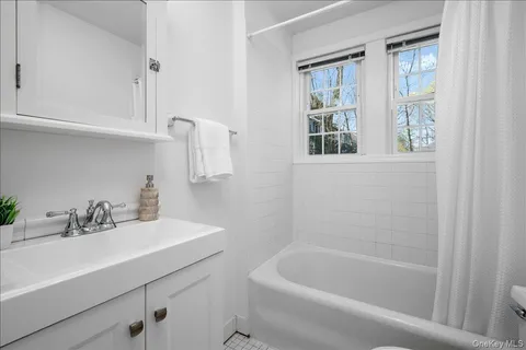 a bathroom with a sink a bathtub and a window